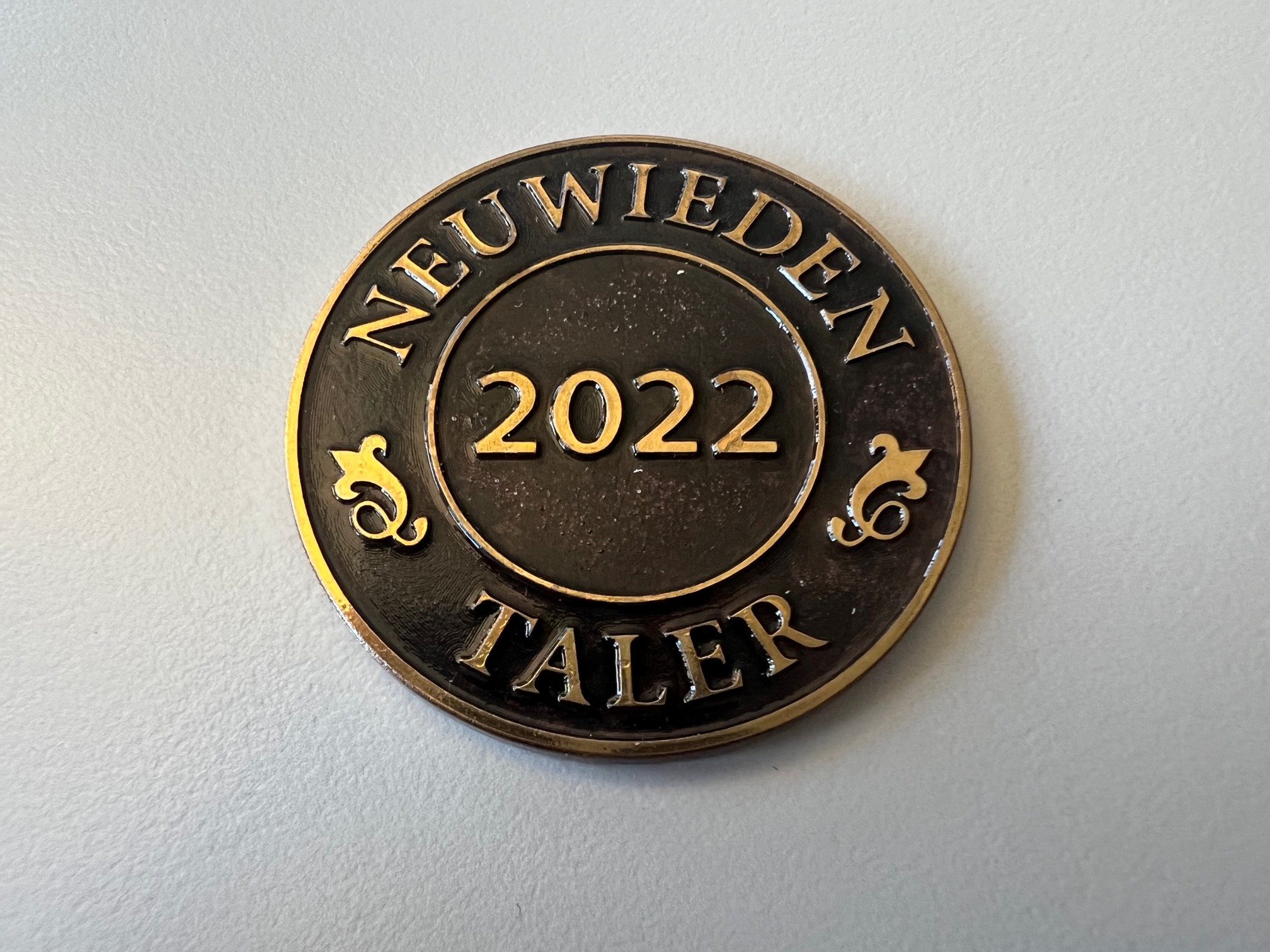 Nahaufnahme einer geprägten Münze mit der Prägung "Neuwieden Taler 2022". Die Jahreszahl steht in der Mitte des Talers.