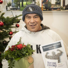 Foto eines Preisträgers des "Neuwieden - Taler 2022". In der linken Hand hält er den Blumenstrauß, in der rechten Hand zeigt er die Urkunde und den Taler in die Kamera. Der Mann trägt einen hellen Kaputzenpullover und eine graue Mütze.
