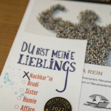 Nachaufnahme einer Urkunde mit einem geprägten Taler mit der Aufschrift "Neuwieden - Taler 2022".