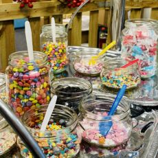 Nahaufnahme von bunten Zuckerperlen in Gläsern.